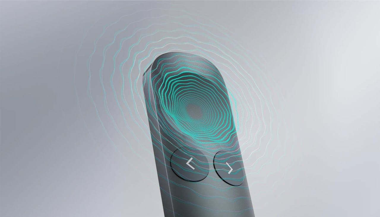 Seseorang menggenggam remote presentasi Logitech Spotlight 2 berwarna hitam dengan indikator lampu menyala